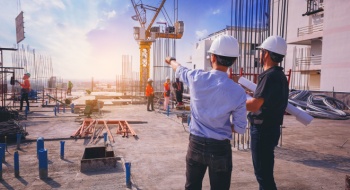 construction workers discussing project plans at a busy worksite