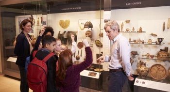Children gather around a museum exhibit on a field trip